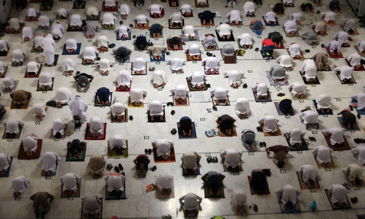 Muçulmanos realizam a oração noturna durante o mês de jejum do Ramadã ao redor da Kaaba no complexo da Grande Mesquita na cidade sagrada de Meca. Apenas pessoas imunizadas contra COVID-19 terão permissão para realizar a peregrinação da Umrah Foto: - / AFP