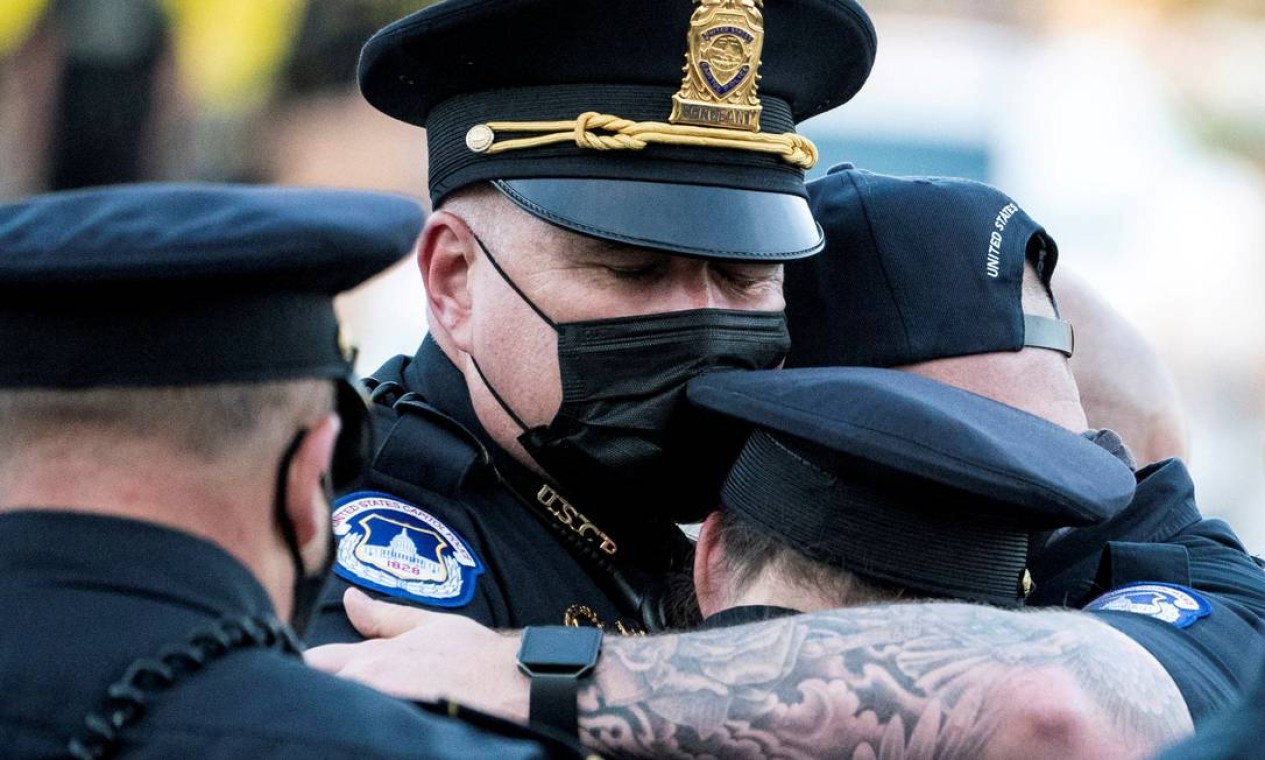 Policiais do Capitólio se abraçam depois durante velório de William Evans, colega morto em serviço em 2 de abril, em Washington, EUA Foto: POOL / REUTERS