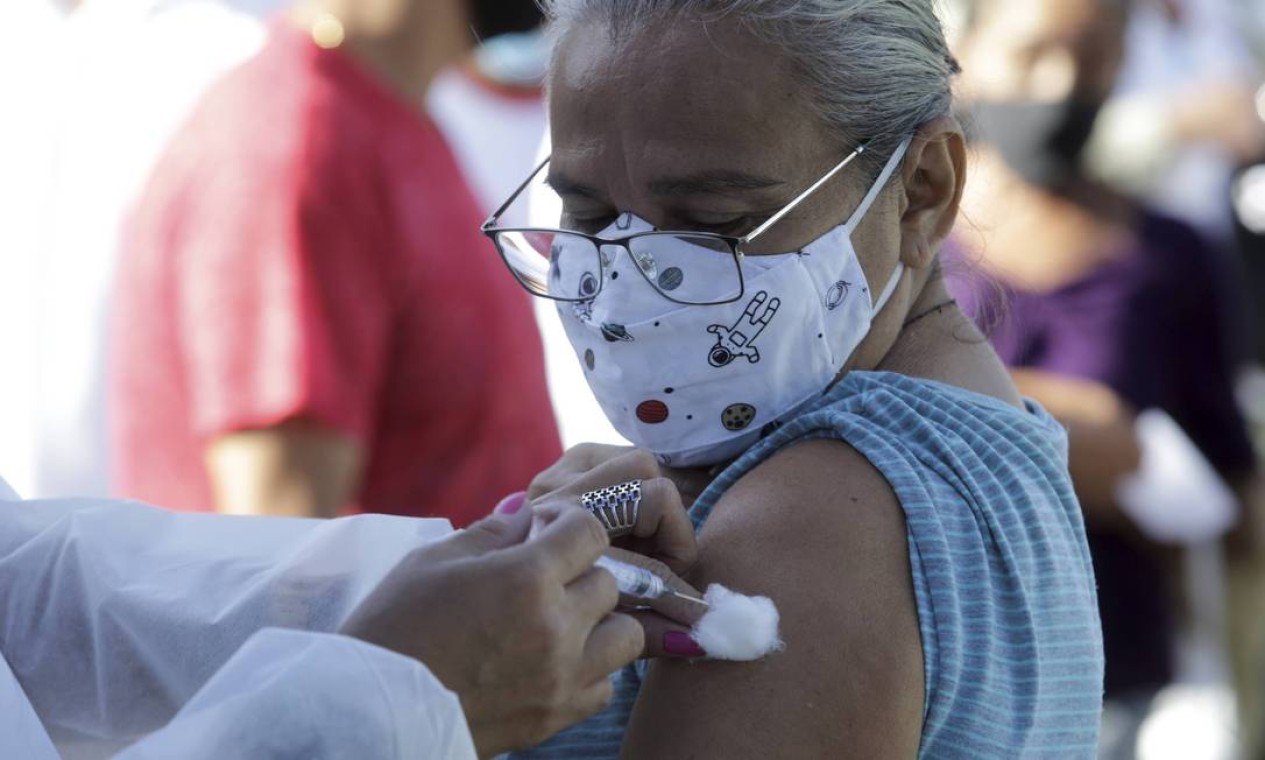 Idosa observa profissional da saúde lhe aplicar vacina contra a Covid-19 Foto: Domingos Peixoto / Agência O Globo