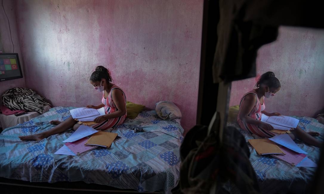 Em Camaragibe, Pernambuco, a estudante Gloria Dayane se prepara para fazer a lição de casa a partir de um texto impresso pelo seu professor de Ciências Foto: LEO MALAFAIA / AFP
