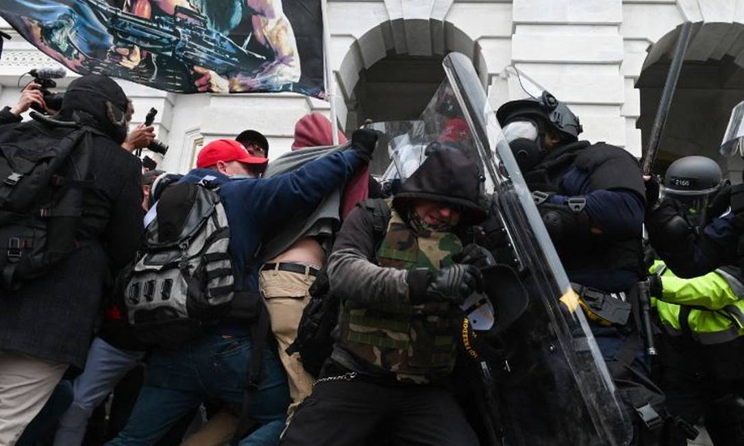 Polícia enfrenta invasores extremistas pró-Trump no Capitólio durante conflito em 6 de janeiro de 2021 Foto: ROBERTO SCHMIDT / AFP