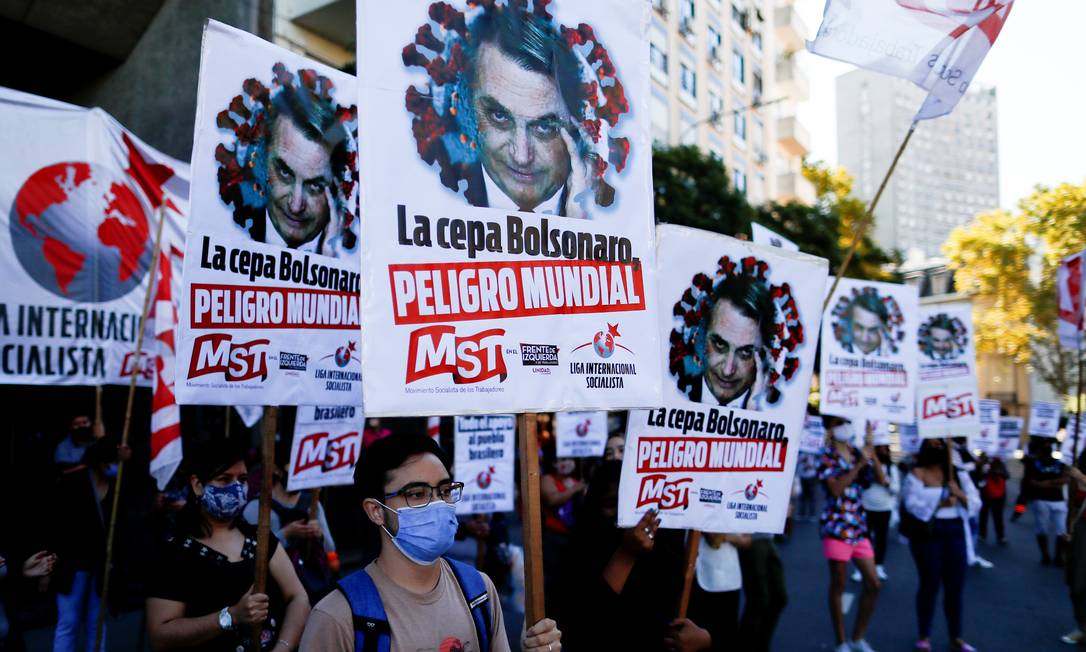 Manifestantes exibem cartazes representando o presidente brasileiro com a frase 