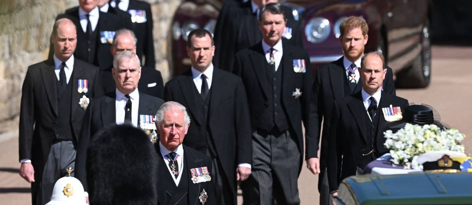 O príncipe William (à esquerda, ao fundo), seu irmão Harry (à direita) e o príncipe Charles (atrás do soldado) na procissão funerária de Philip no Castelo de Windsor Foto: LEON NEAL / AFP