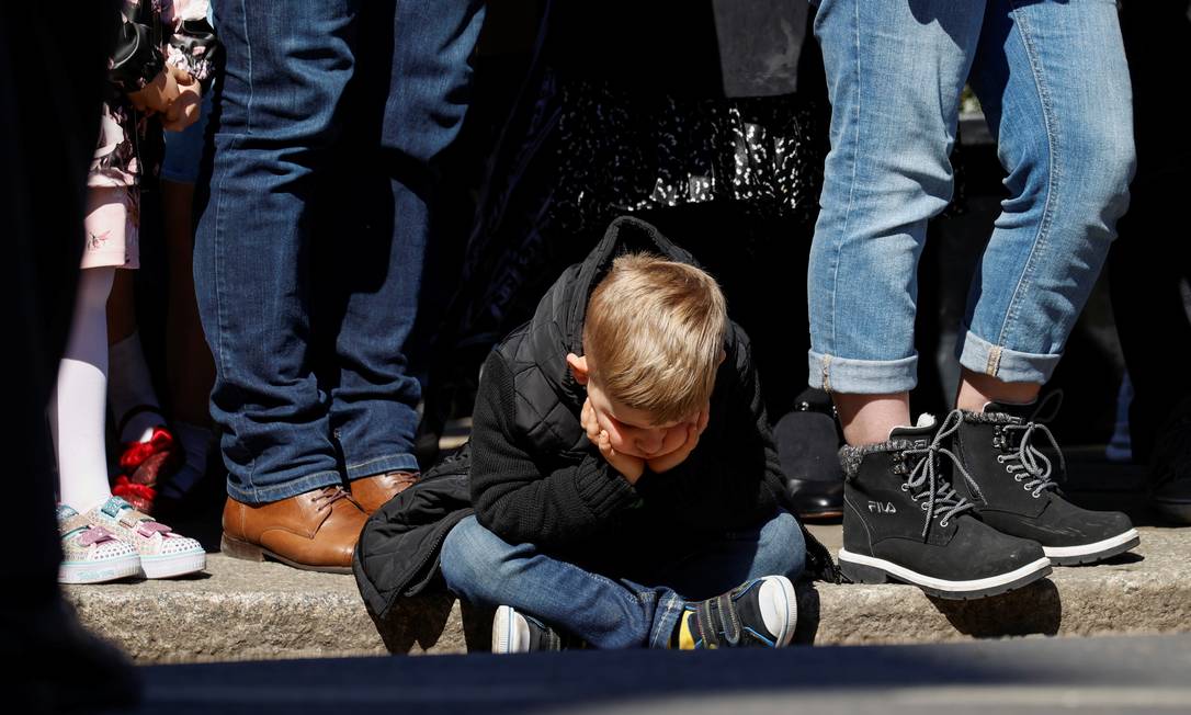 Criança durante minuto de silêncio, do lado de fora do Castelo de Windsor Foto: PHIL NOBLE / REUTERS