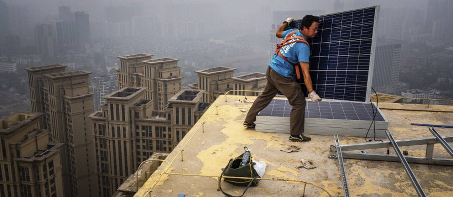 Homem instala painéis solares no topo de um edifício de 47 andares em Wuhan, na China; país fabrica 60% dos dispositivos do tipo no mundo Foto: BRYAN DENTON / NYT/5-7-18
