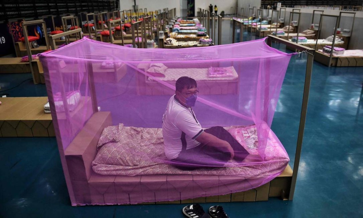Funcionário da Administração Metropolitana de Bangkok testa uma cama para pacientes de coronavírus Covid-19 que chegam em um novo hospital de campanha montado em ginásio Foto: LILLIAN SUWANRUMPHA / AFP
