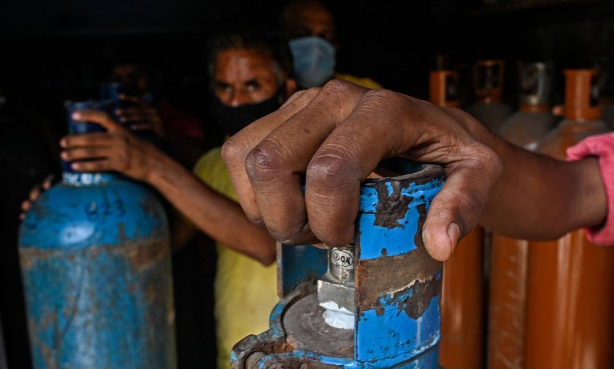 Trabalhadores vistos em uma instalação que fornece cilindros médicos de oxigênio para uso hospitalar em pacientes com coronavírus Covid-19 em meio ao aumento de casos em Mumbai, Índia Foto: INDRANIL MUKHERJEE / AFP