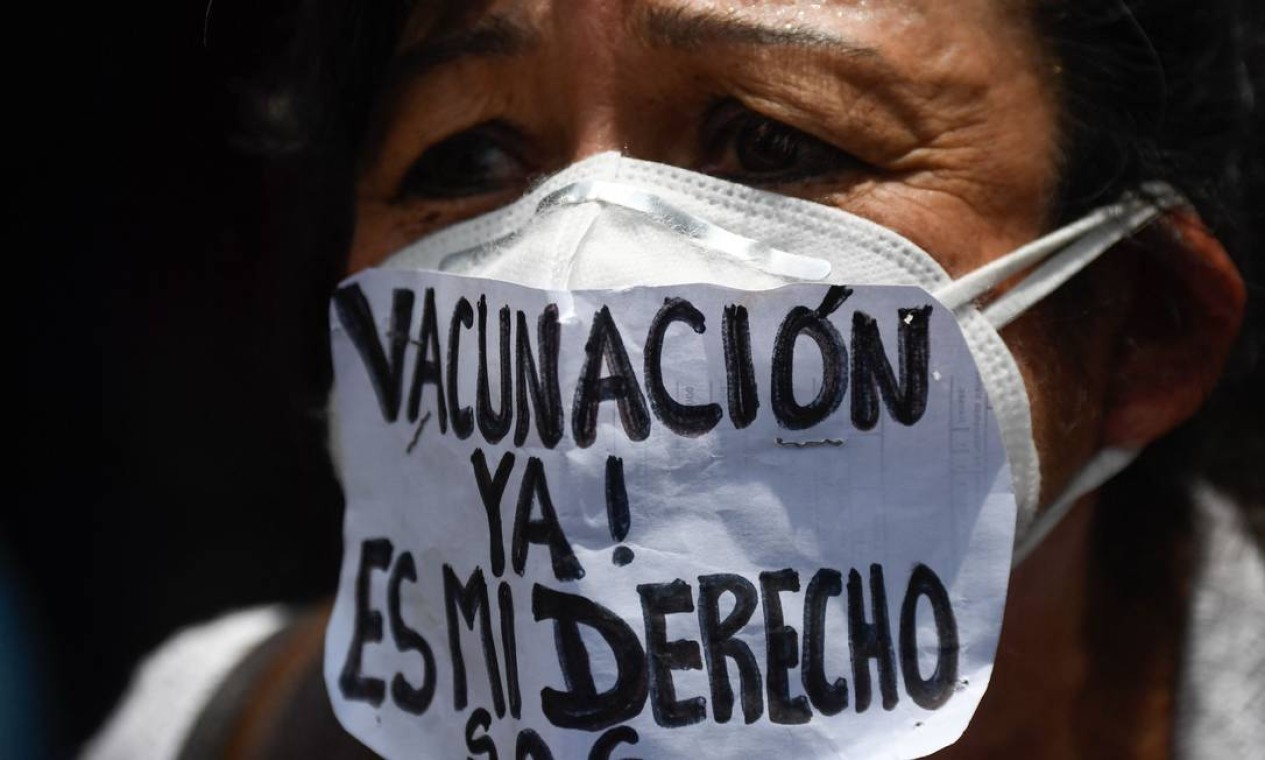 Enfermeira usa máscara escrita "Vacinação já! É meu direito" durante protesto para exigir que todos os profissionais de saúde sejam vacinados contra COVID-19, na praça Los Palos Grandes, em Caracas, Venezuela Foto: FEDERICO PARRA / AFP