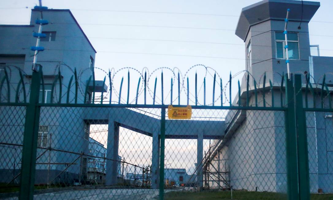 Cerca do lado de fora do que é oficialmente um centro de educação vocacional em Xinjiang, na China. Segundo a Human Rights Watch, local é usado para prender, torturar e eventualmente matar integrantes da minoria uigur na região Foto: Thomas Peter / REUTERS