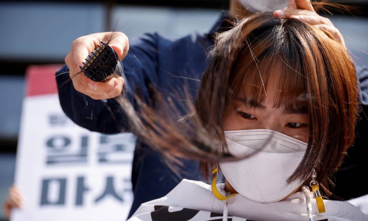 Estudante universitária da Coreia do Sul tem a cabeça raspada durante um protesto contra a decisão do Japão de liberar água contaminada de sua usina nuclear danificada de Fukushima no mar, em frente à embaixada do Japão, em Seul, Coreia do Sul Foto: KIM HONG-JI / REUTERS
