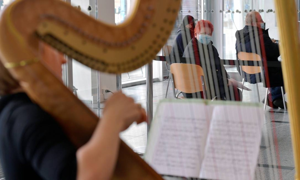 A harpista Sarah Christ se apresenta em um centro de testes rápidos de COVID-19 localizado no Palácio da Cultura, em Dresden, Alemanha Foto: MATTHIAS RIETSCHEL / REUTERS