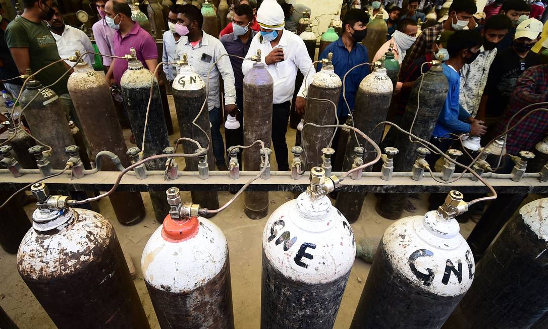 Pessoas recarregam cilindros de oxigênio para pacientes de Covid-19 em Allahabad, na região metropolitana de Uttar Pradesh, Índia Foto: SANJAY KANOJIA / AFP/20-04-2021