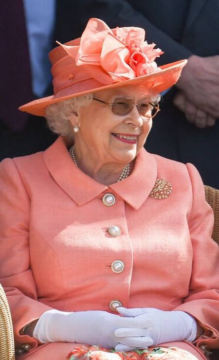 A rainha também adora tons pastel. Elizabeth escolheu um sobretudo laranjinha e um chapéu na mesma cor, decorado com um laço, para cumprir um compromisso de sua agenda, realizado na parte da manhã Foto: Getty Images