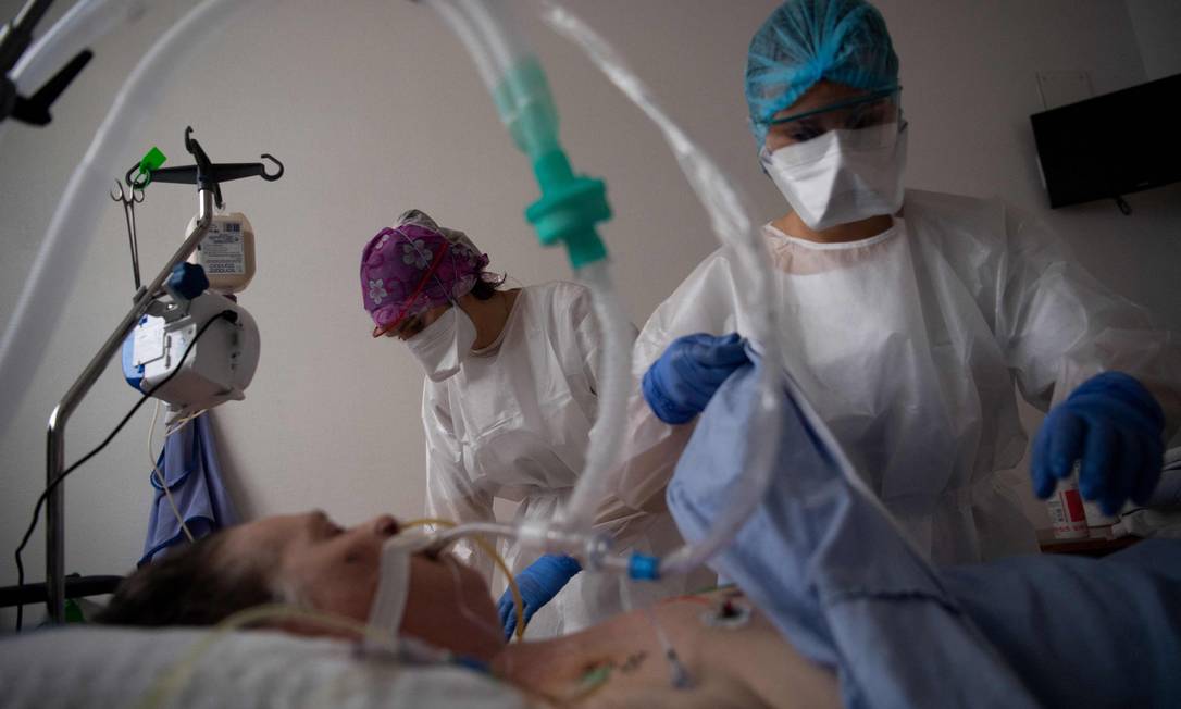 Equipe médica cuida de um paciente infectado com Covid-19 em UTI de hospital em Vannes, oeste da França Foto: LOIC VENANCE / AFP - 20/04/2021