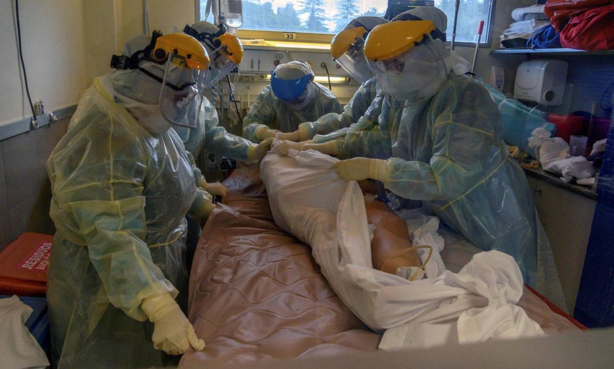 Trabalhadores de saúde atendem paciente em Unidade de Terapia Intensiva (UTI) Covid-19, em hospital privado de Montevidéu, em 20 de abril de 2021. Foto: PABLO PORCIUNCULA / AFP