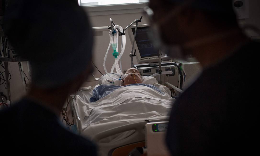 Membros da equipe médica observam um paciente com Covid-19 na UTI do hospital Clinique Oceane, em Vannes, oeste da França Foto: LOIC VENANCE / AFP