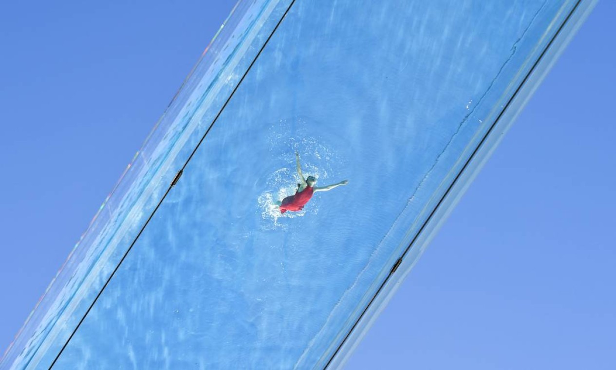 Nadador atravessa uma piscina de acrílico transparente fixada entre dois blocos de apartamentos em Embassy Gardens, em Londres. Inovação tem 25 metros de comprimento e permite que os residentes nadem de um prédio para o outro, a dez andares acima do solo Foto: JUSTIN TALLIS / AFP