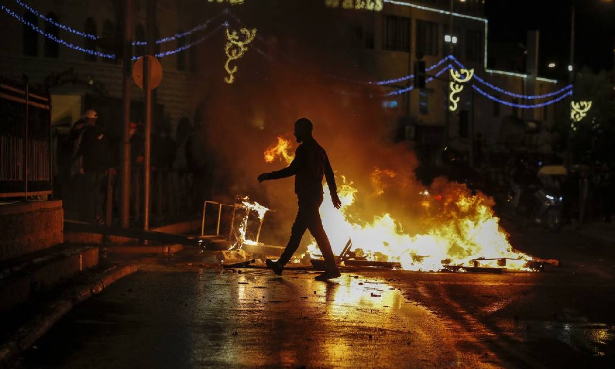 Ruas são incendiadas enquanto membros das forças de segurança israelenses se posicionam durante confrontos com manifestantes palestinos do lado de fora do Portão de Damasco, na Cidade Velha de Jerusalém Foto: AHMAD GHARABLI / AFP