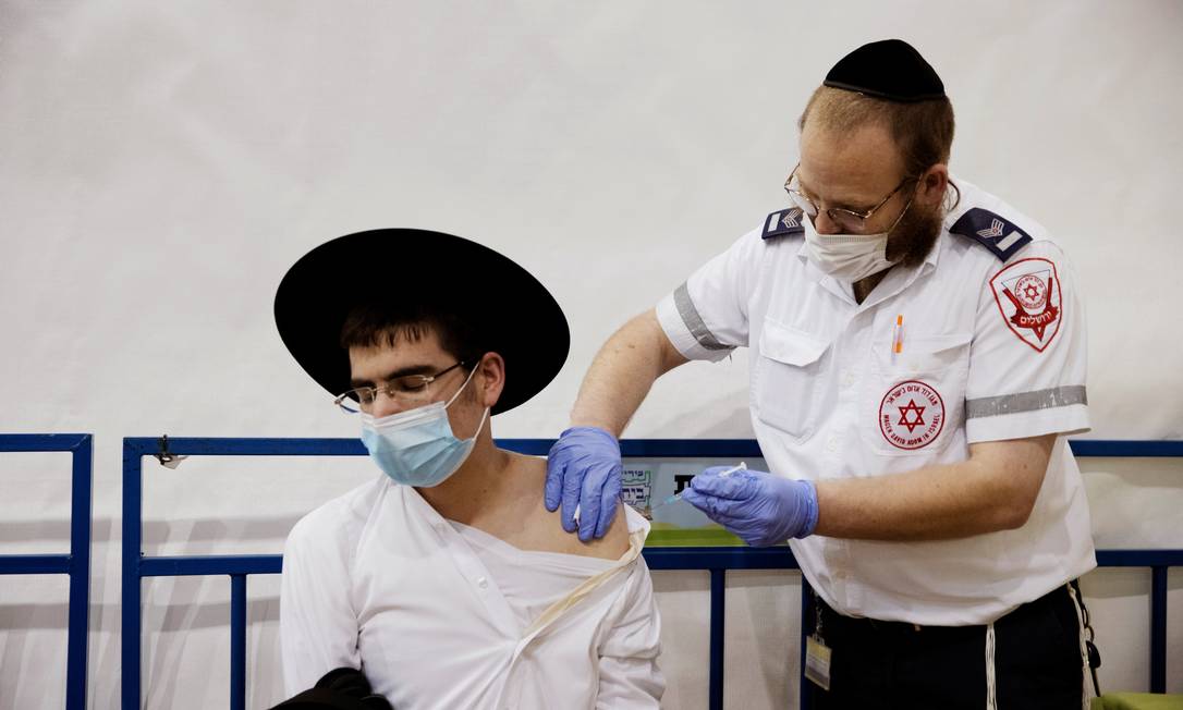 Judeu ultra-ortodoxo é vacinado contra a Covid-19, em Israel: país não teve nenhuma morte pela doença na sexta-feira Foto: RONEN ZVULUN / REUTERS