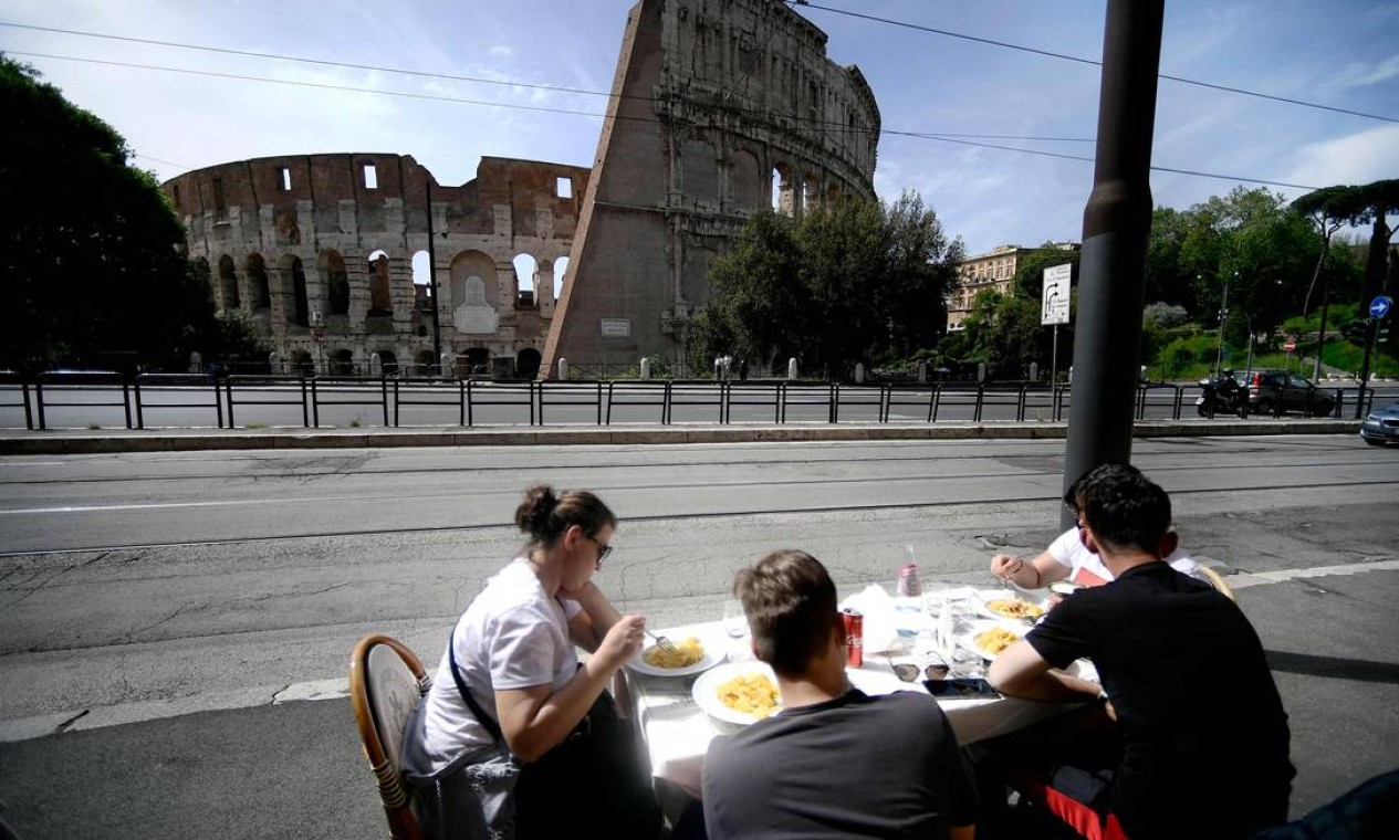 Pessoas comem perto do Coliseu Foto: FILIPPO MONTEFORTE / AFP
