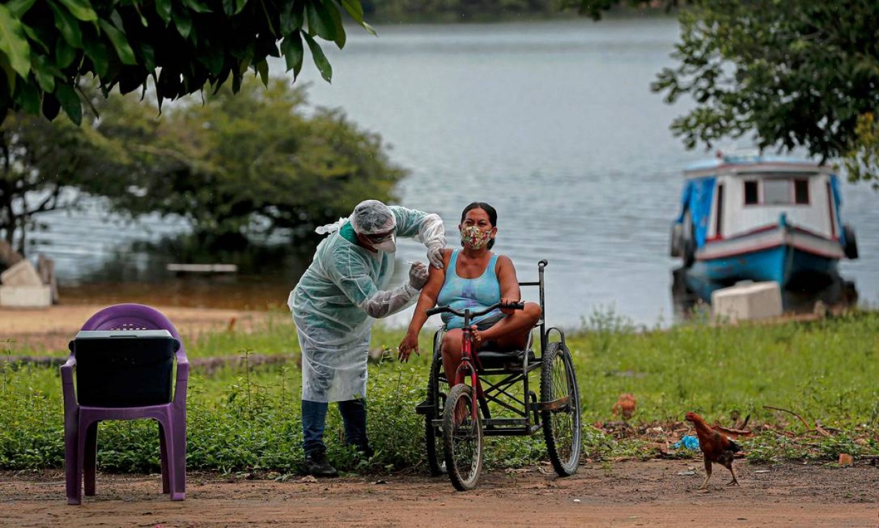 Profissional de saúde da Secretaria de Saúde Indígena do Ministério da Saúde administra uma segunda dose da vacina contra COVID-19 a uma mulher da aldeia Esperança do Rio Arapiun, no Baixo Amazonas, estado do Pará, próximo a Santarém Foto: TARSO SARRAF / AFP