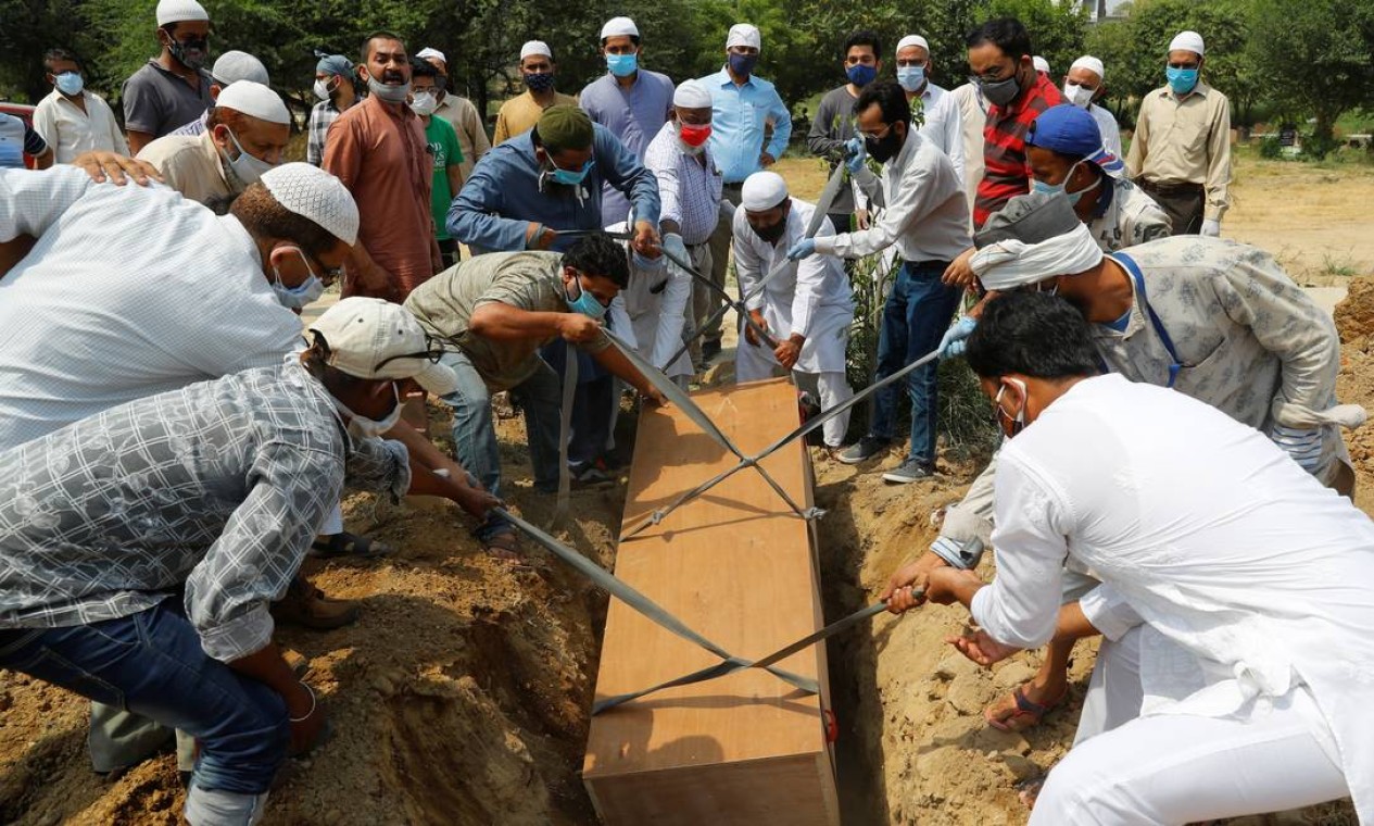 Familiares e coveiros enterram homem de 67 anos que morreu em Nova Délhi Foto: ADNAN ABIDI / REUTERS