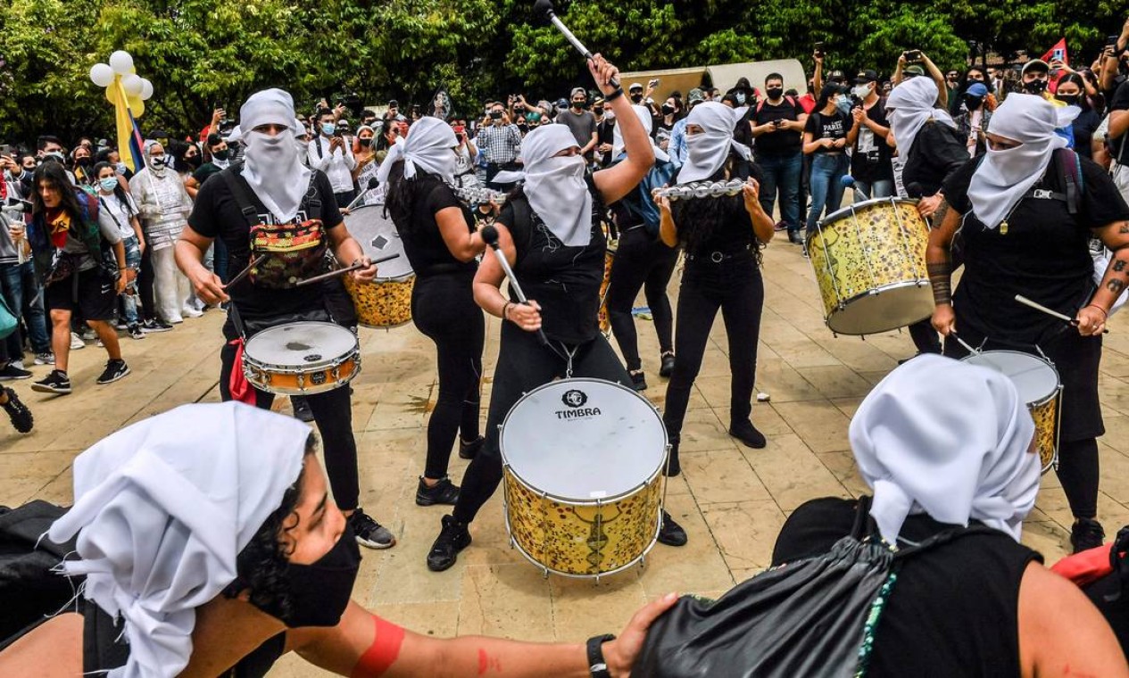 Manifestantes mascarados tocam percussão durante protesto contra o projeto de reforma tributária lançado pelo presidente colombiano Ivan Duque, em Medellín Foto: Joaquin Sarmiento / AFP