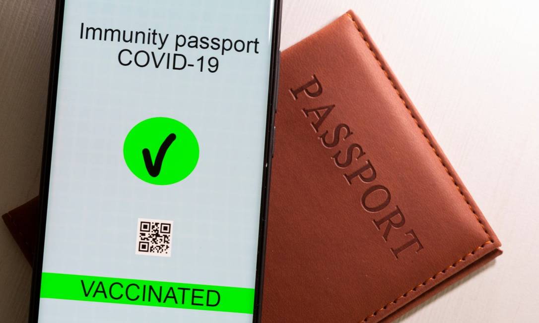 Foto ilustrativa mostra smartphone com "passaporte da Covid" ao lado de um passaporte Foto: DADO RUVIC / REUTERS