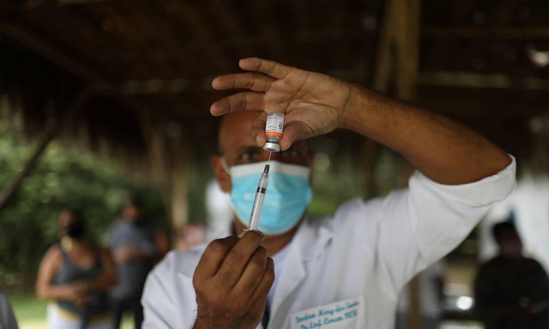 Profissional de saúde vacina em quilombo de Magé Foto: PILAR OLIVARES/Reuters / Reuters