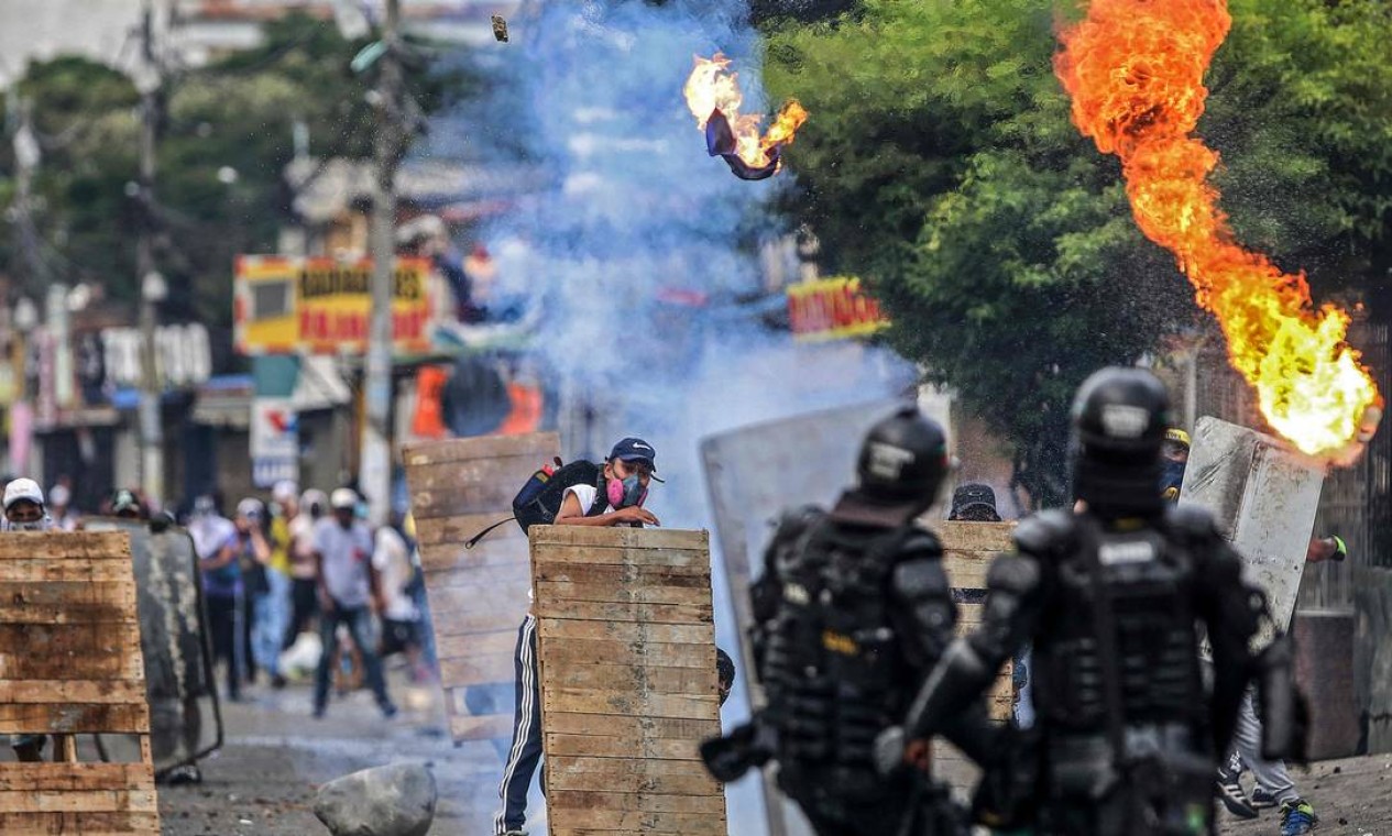 Manifestantes enfrentam tropas de choque durante protesto contra projeto de reforma tributária lançado pelo presidente colombiano Ivan Duque, em Cali, Colômbia Foto: PAOLA MAFLA / AFP