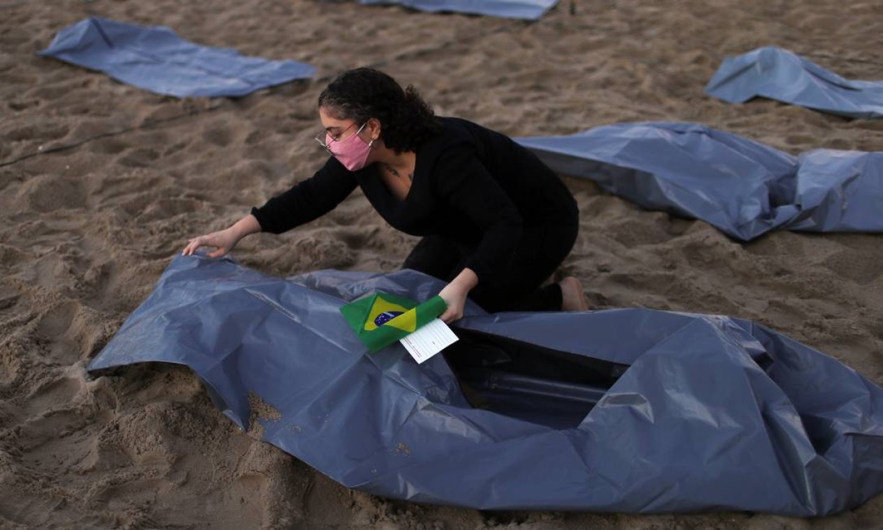 Mulher ajusta uma das sacolas plásticas representando corpos, expostas por ativistas da ONG Rio de Paz durante protesto Foto: Pilar Olivares / Reuters