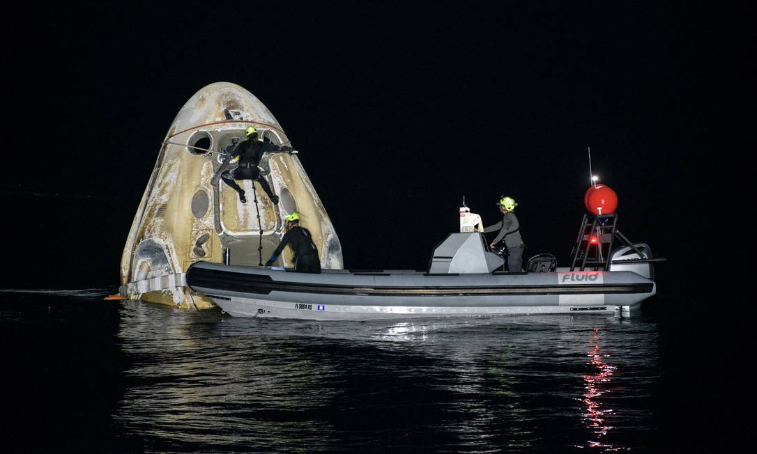 As equipes de apoio trabalham em torno da espaçonave SpaceX Crew Dragon Resilience logo após ela pousar no Golfo do México Foto: NASA/Bill Ingalls / via REUTERS