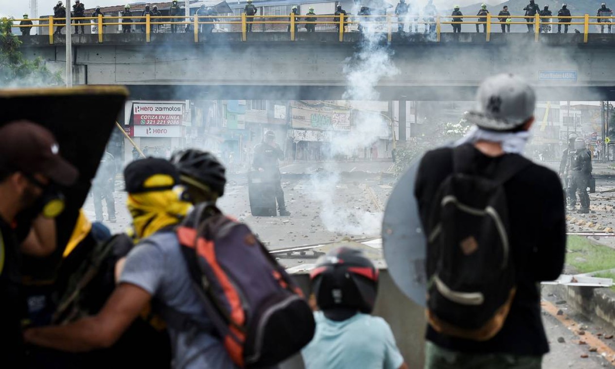 Manifestantes enfrentam tropas de choque durante confrontos em Cali Foto: LUIS ROBAYO / AFP