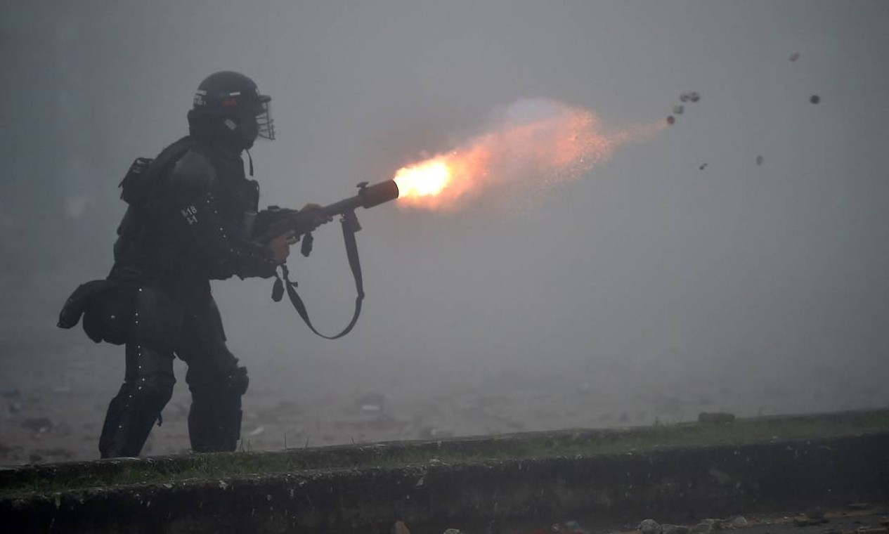 Policial de choque dispara gás lacrimogêneo contra manifestantes Foto: LUIS ROBAYO / AFP