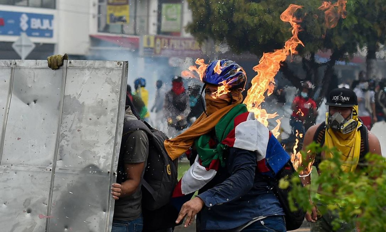 Manifestante é atingido por um coquetel molotov lançado durante confrontos com policiais de choque durante um protesto contra uma proposta de reforma tributária do governo em Cali Foto: LUIS ROBAYO / AFP