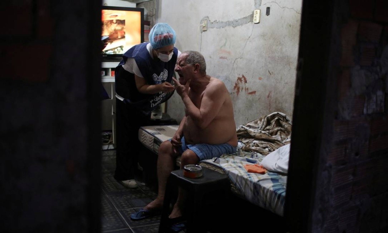 Carlos Alberto Tabares de Oliveira, 64 anos, recebe em casa a vacina da AstraZeneca contra Covid-19, na favela da Rocinha, Zona Sul do Rio Foto: Pilar Olivares / Reuters - 16/04/2021