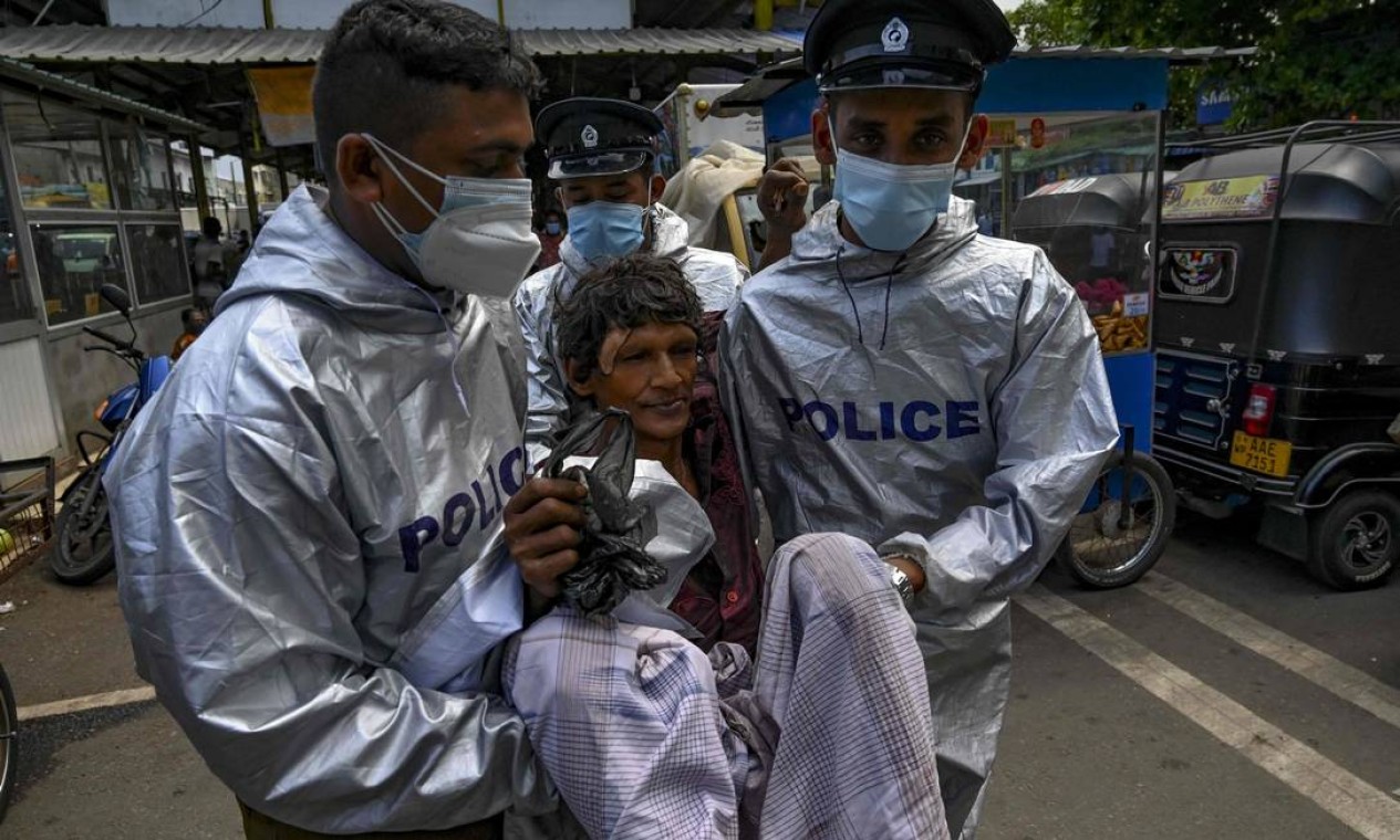 Policiais prendem homem por não usar máscara facial em Colombo, capital do Sri Lanka, que está reprimindo pessoas que violam as regulamentações de saúde para tentar controlar surto de infecções por coronavírus Foto: ISHARA S. KODIKARA / AFP