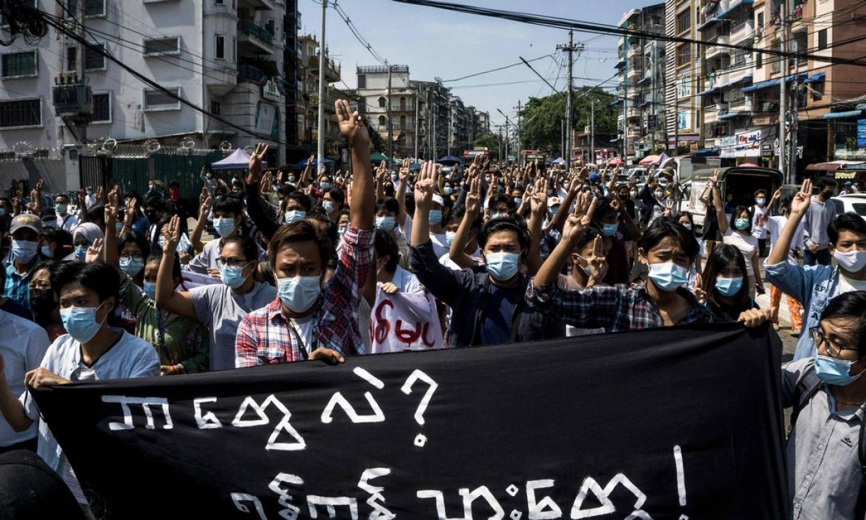 Manifestantes seguram uma faixa que diz: "Quem somos nós? Residentes de Yangon" durante uma manifestação contra o golpe militar em Yangon, Mianmar Foto: STR / AFP