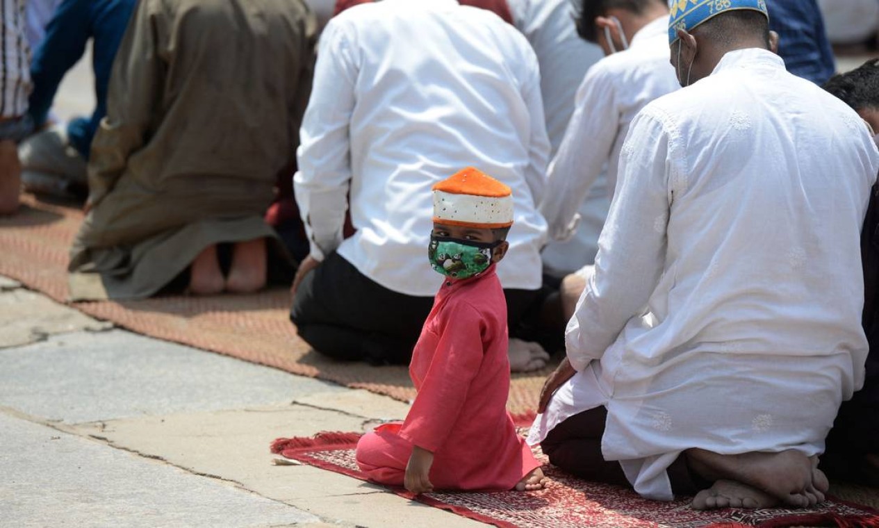 Menino olha para trás enquanto muçulmanos prestam as orações na última sexta-feira do mês sagrado do Ramadã, em Mecca Masjid, em Hyderabad, na Índia Foto: NOAH SEELAM / AFP