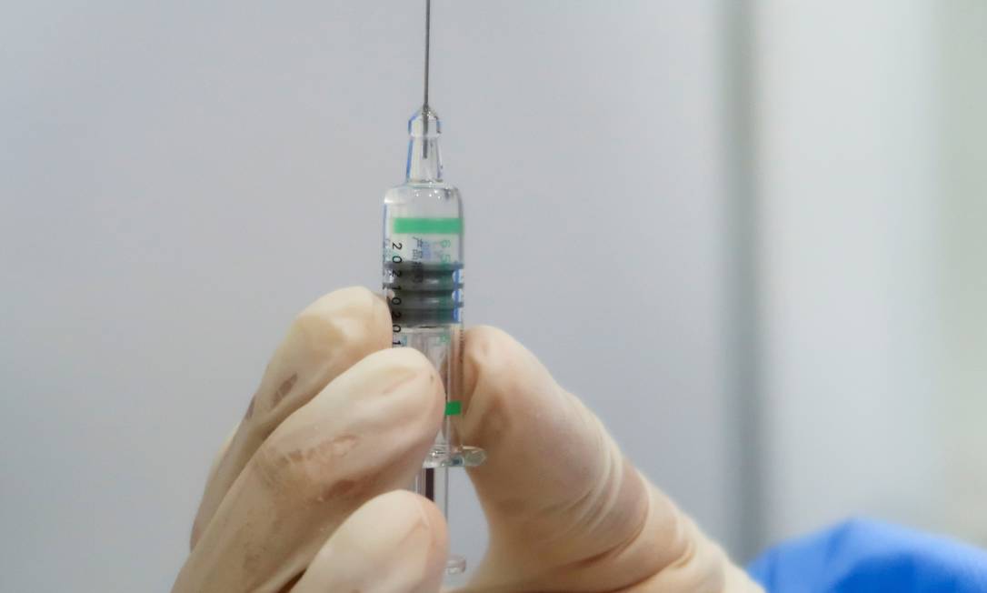 Enfermeira segura uma seringa contendo a vacina contra a Covid-19 produzida pelo Instituto de Produtos Biológicos de Pequim, uma unidade da subsidiária da Sinopharm Foto: THOMAS PETER / REUTERS