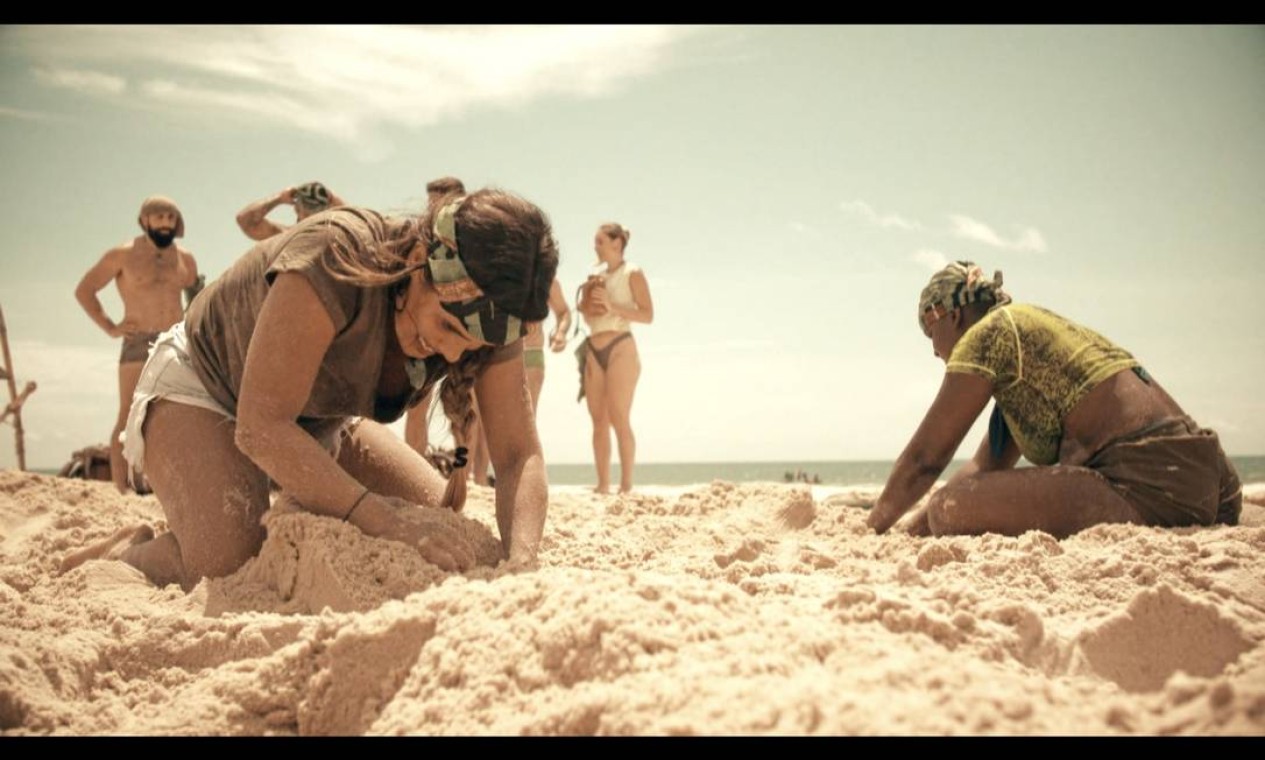 Carol Peixinho e Angélica com a mão na areia em 'No Limite' Foto: Divulgação/TV Globo