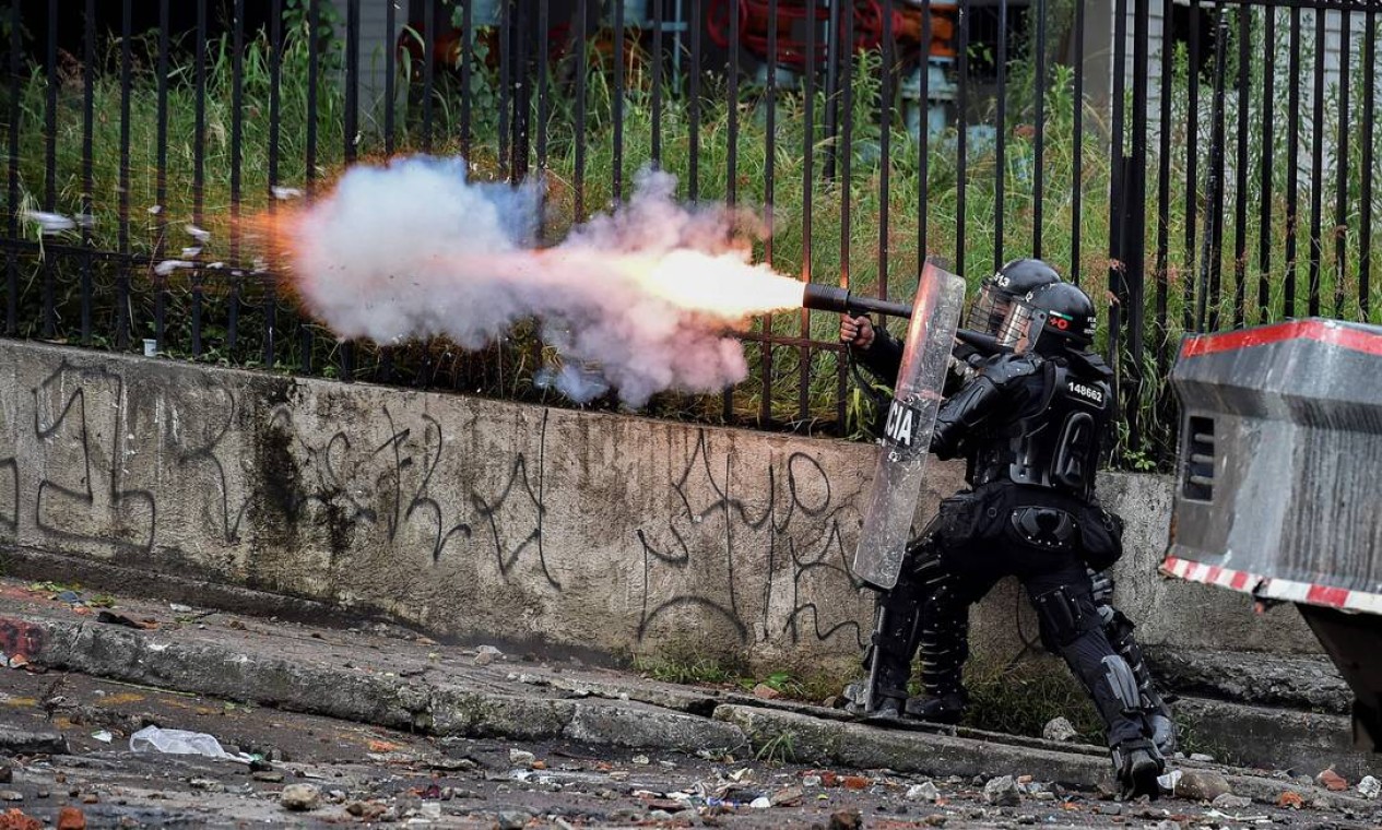 Policial de choque dispara gás lacrimogêneo contra manifestantes durante um protesto contra o governo em Cali, Colômbia Foto: LUIS ROBAYO / AFP