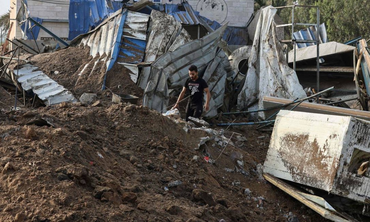 Homem inspeciona os escombros de um prédio destruído por ataques aéreos israelenses em Gaza Foto: MAHMUD HAMS / AFP