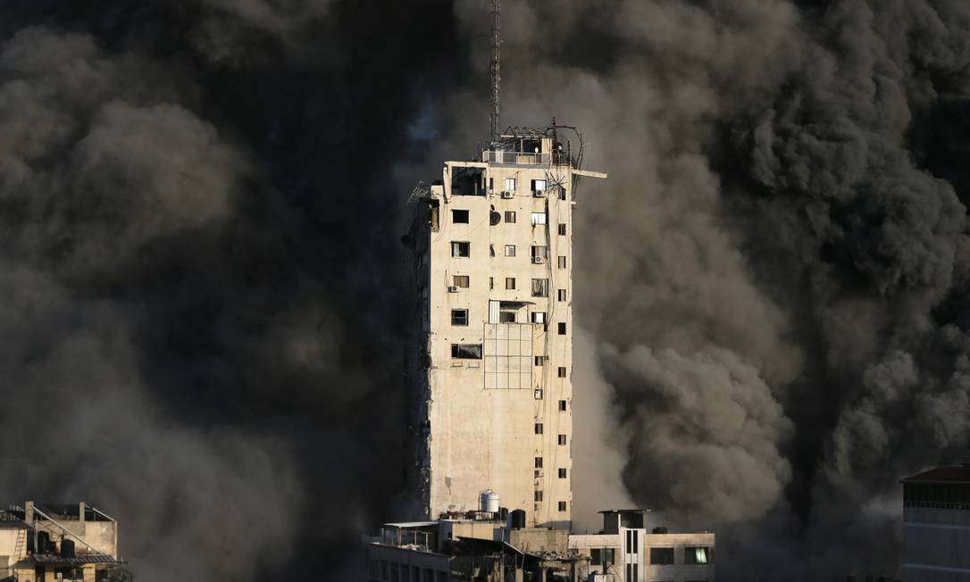 Imensa cortina de fumaça é vista por trás do edifício Foto: IBRAHEEM ABU MUSTAFA / REUTERS