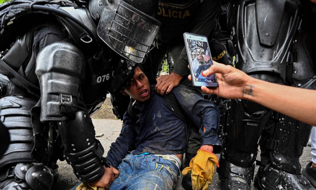 Policiais colombianos prendem manifestante em Cali, Colômbia. Manifestações, que já deixaram 42 mortos, começaram no fim de abril Foto: LUIS ROBAYO / AFP - 10/05/2021