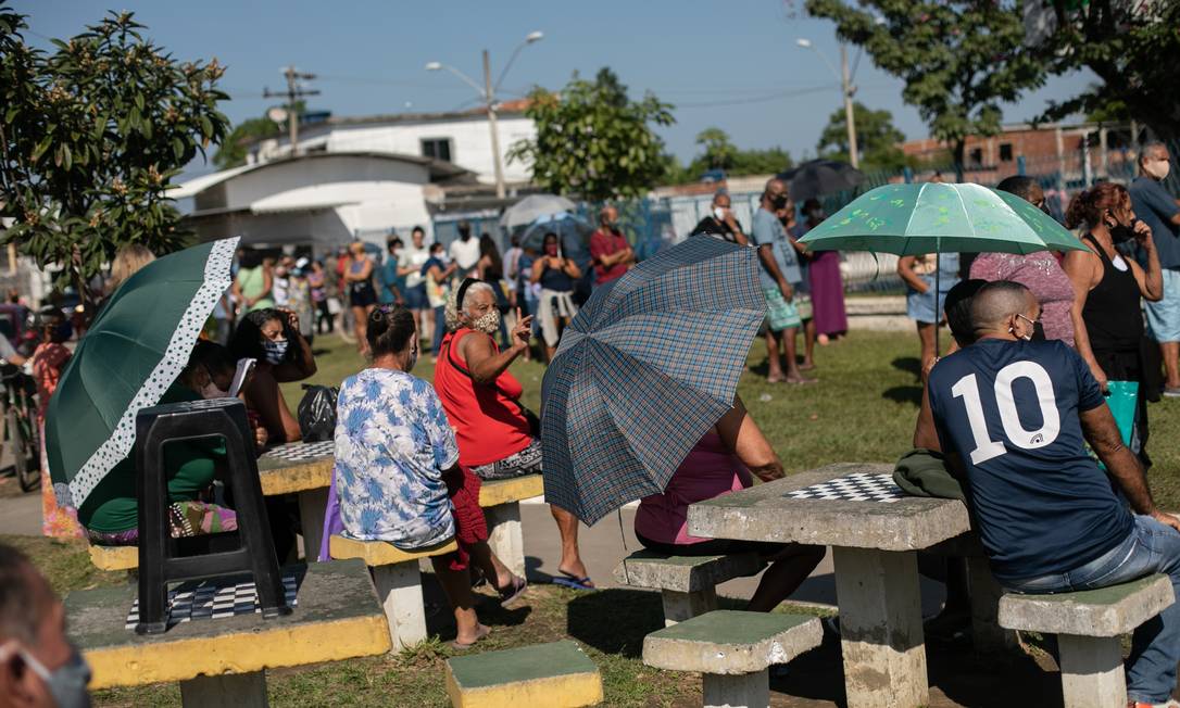 Algumas pessoas usavam guarda-chuvas para tentar se proteger do sol forte Foto: Brenno Carvalho / Agência O Globo