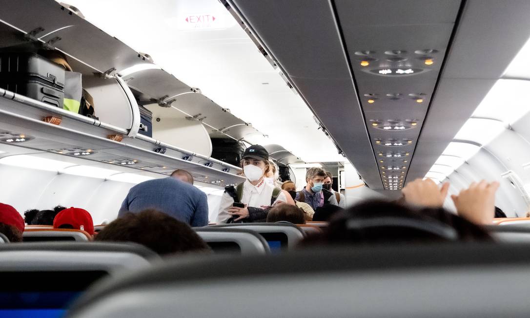 Viajantes em avião no Aeroporto de Orlando, na Flória Foto: ERIN SCHAFF / NYT
