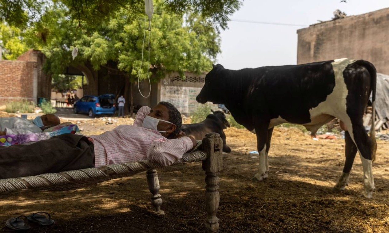 Com dificuldade em respirar, Roshan Lal, de 48 anos, ocupa leito de clínica improvisada ao ar livre na Índia Foto: DANISH SIDDIQUI / REUTERS