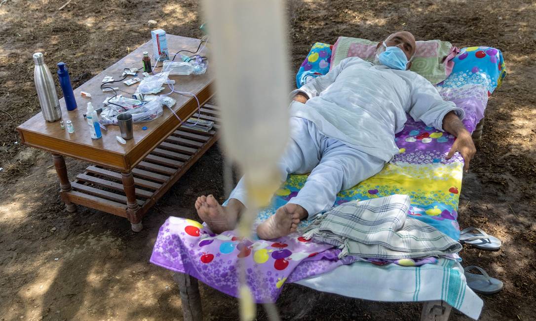 Com Covid-19, Harveer Singh, de 65 anos, recebe tratamento embaixo de árvore na Índia Foto: DANISH SIDDIQUI / REUTERS