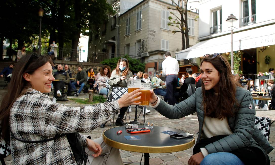 Clientes brindam no terraço de um café em Montmartre, em Paris, onde os espaços externos de bares e restaurantes foram abertos hoje Foto: SARAH MEYSSONNIER / REUTERS
